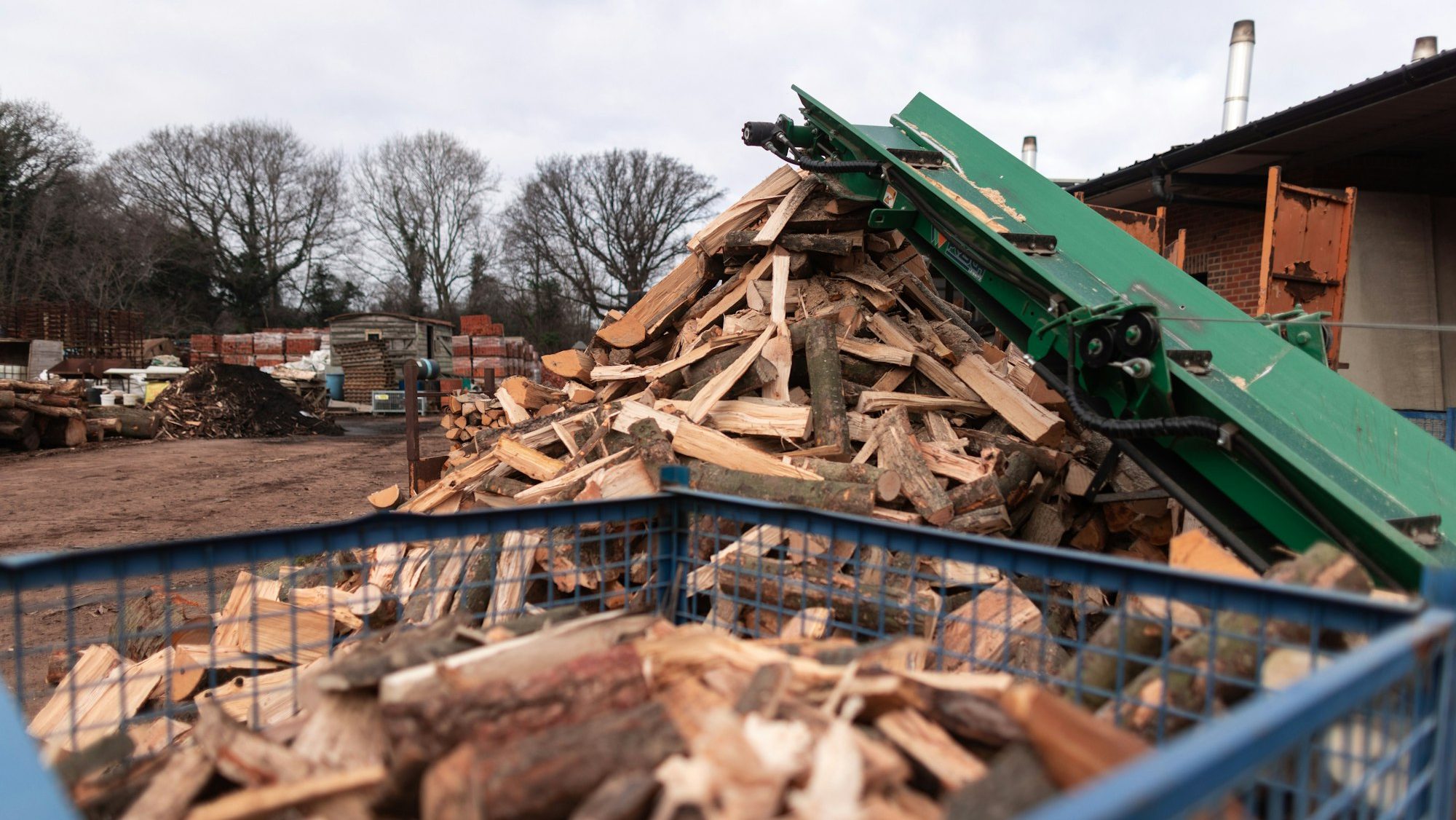 the dumpster is filled with chopped wood outside of a building